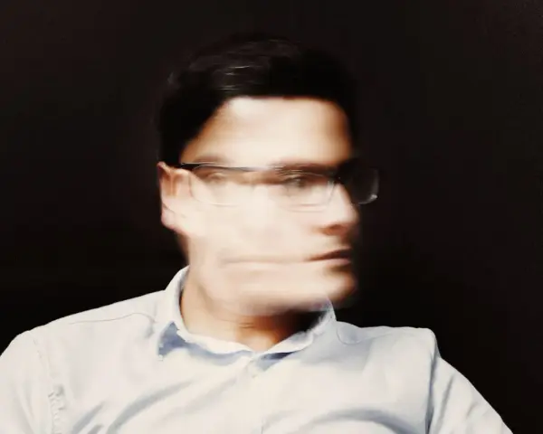 Uomo con occhiali, volto sfocato, espressione pensierosa, forse una crisi mezza età uomo.