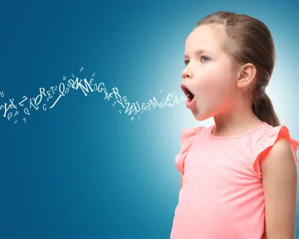 Bambina con lettere che escono dalla bocca, simbolo dello sviluppo del linguaggio.