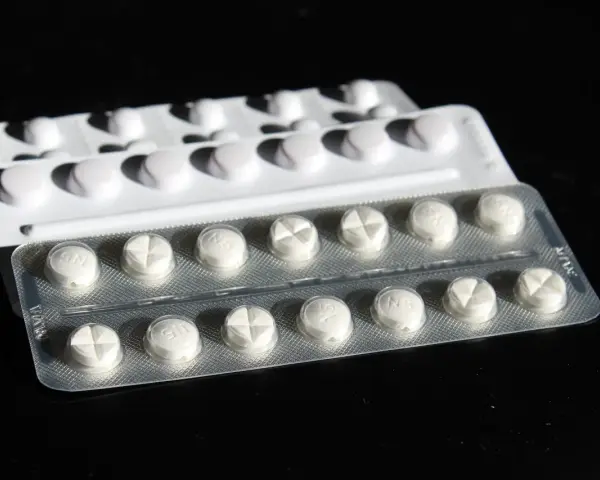 Blister di pillole bianche, alcune con incisione a croce. Potrebbe trattarsi di cardioaspirina in gravidanza, un farmaco da usare con cautela.