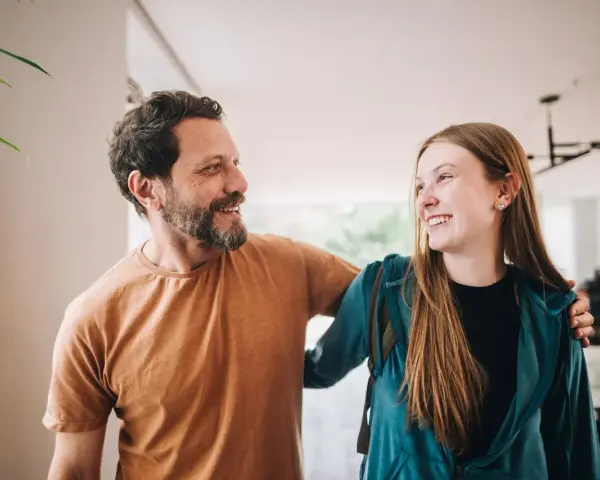 Un padre e una figlia, uniti da un sorriso, si guardano con affetto. La loro complicità è palpabile, un legame forte che supera ogni distanza.