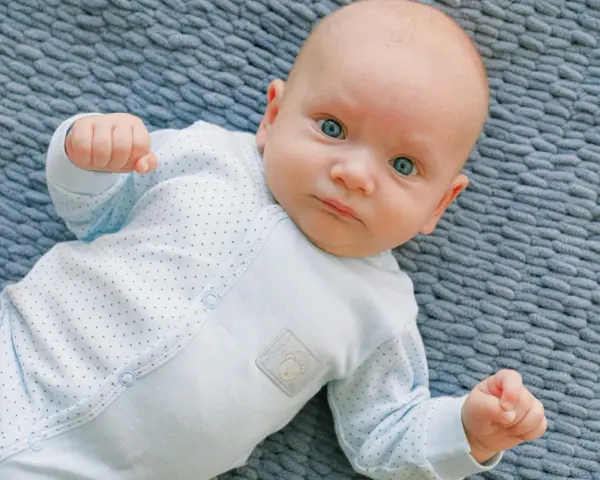 Un bimbo con occhi azzurri, un riflesso di moro autismo, gioca sul tappeto.