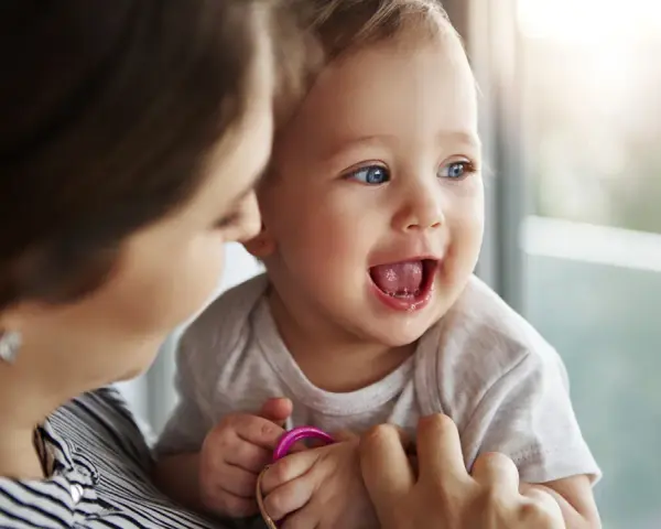 Bambino sorridente con mamma, forse è l'inizio della lallazione.