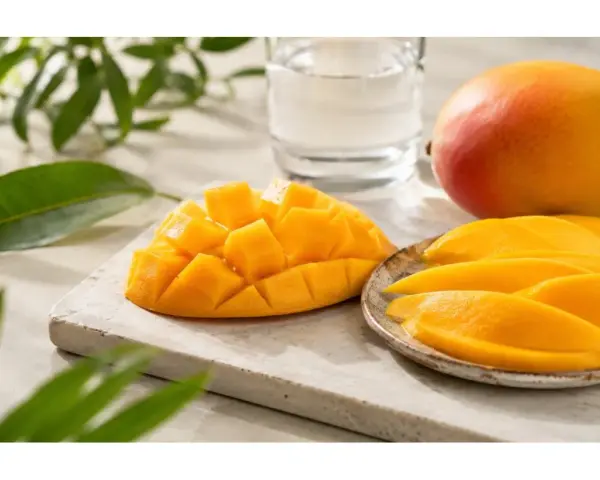 Un succoso mango, tagliato a cubetti e a fette, pronto per essere gustato. Sembra un mango in gravidanza, pieno di dolcezza e vitalità.