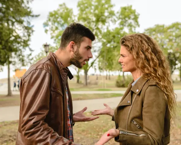 Coppia discute animatamente in un parco. Lui sembra frustrato, lei perplessa, forse per un attaccamento morboso alla famiglia di origine che ostacola la loro relazione.