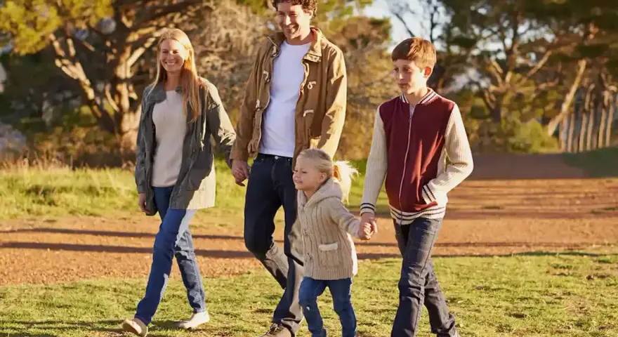 Famiglia felice passeggia nel parco, godendosi il **tempo di qualità** insieme.