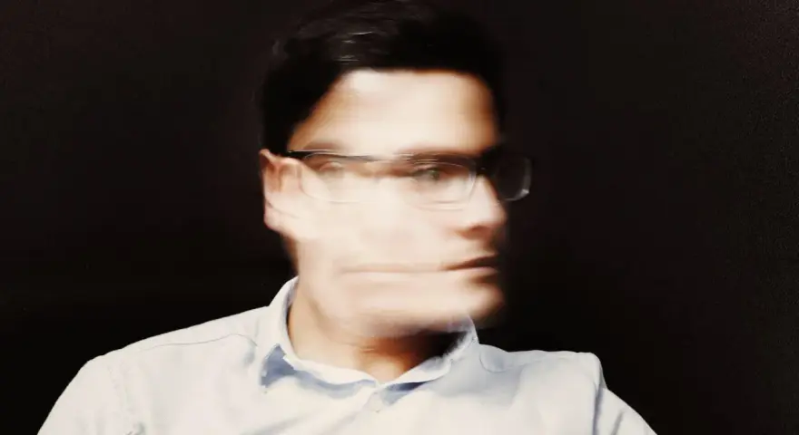 Uomo con occhiali, volto sfocato, espressione pensierosa, forse una crisi mezza età uomo.