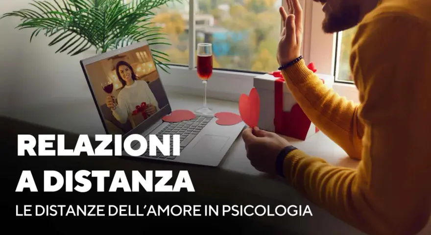 Coppia in videochiamata, lei con bicchiere di vino e regalo, lui saluta. Mi sento come se mio marito non mi desse attenzioni, ma la distanza è dura.