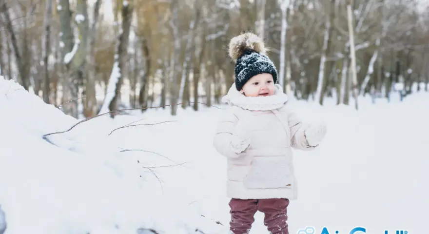 Bambino in montagna, con cappello di lana e guanti, immerso nella neve. Un'avventura invernale per i più piccoli.