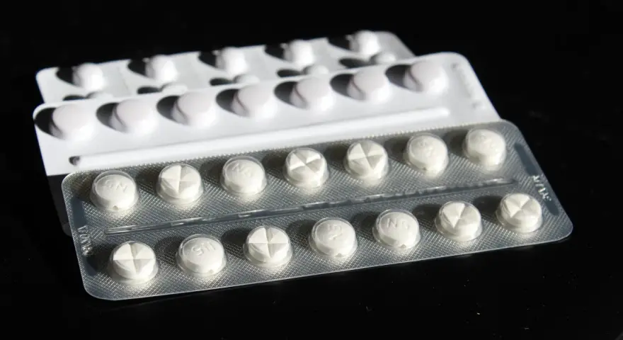 Blister di pillole bianche, alcune con incisione a croce. Potrebbe trattarsi di cardioaspirina in gravidanza, un farmaco da usare con cautela.