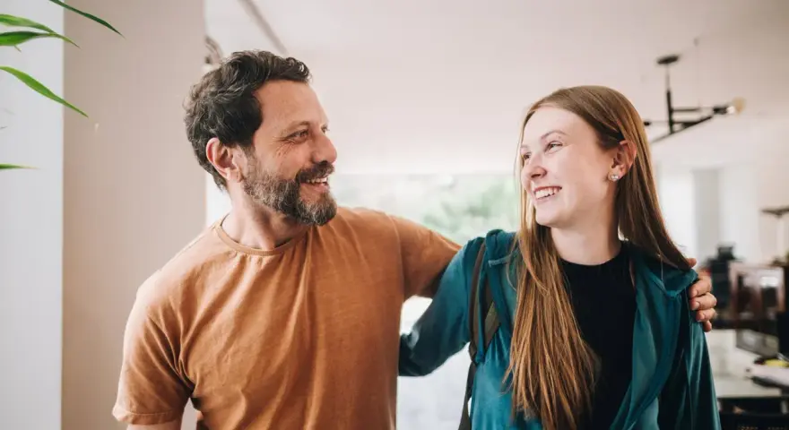 Un padre e una figlia, uniti da un sorriso, si guardano con affetto. La loro complicità è palpabile, un legame forte che supera ogni distanza.