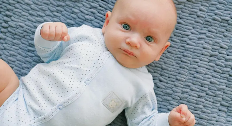 Un bimbo con occhi azzurri, un riflesso di moro autismo, gioca sul tappeto.