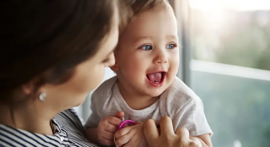 Bambino sorridente con mamma, forse è l'inizio della lallazione.