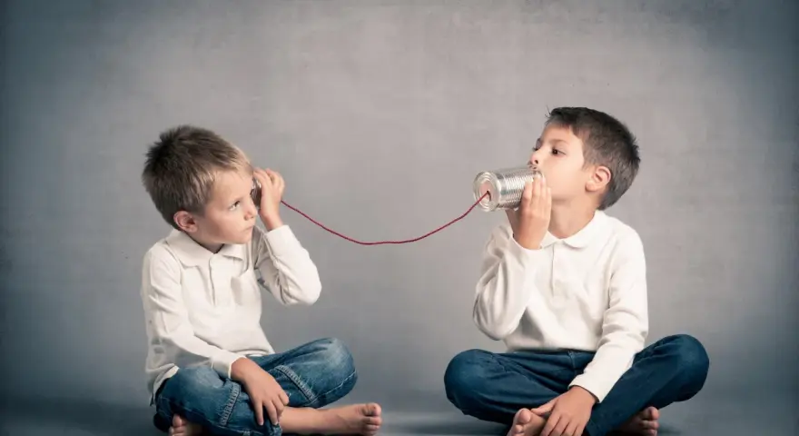 Due bambini comunicano con un telefono di latta. Come mio figlio ha iniziato a parlare a 4 anni, mi immagino che stiano condividendo segreti.