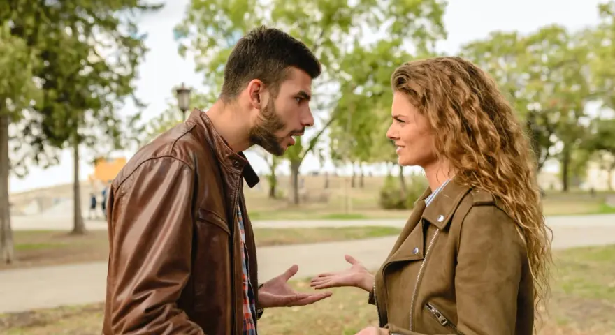 Coppia discute animatamente in un parco. Lui sembra frustrato, lei perplessa, forse per un attaccamento morboso alla famiglia di origine che ostacola la loro relazione.
