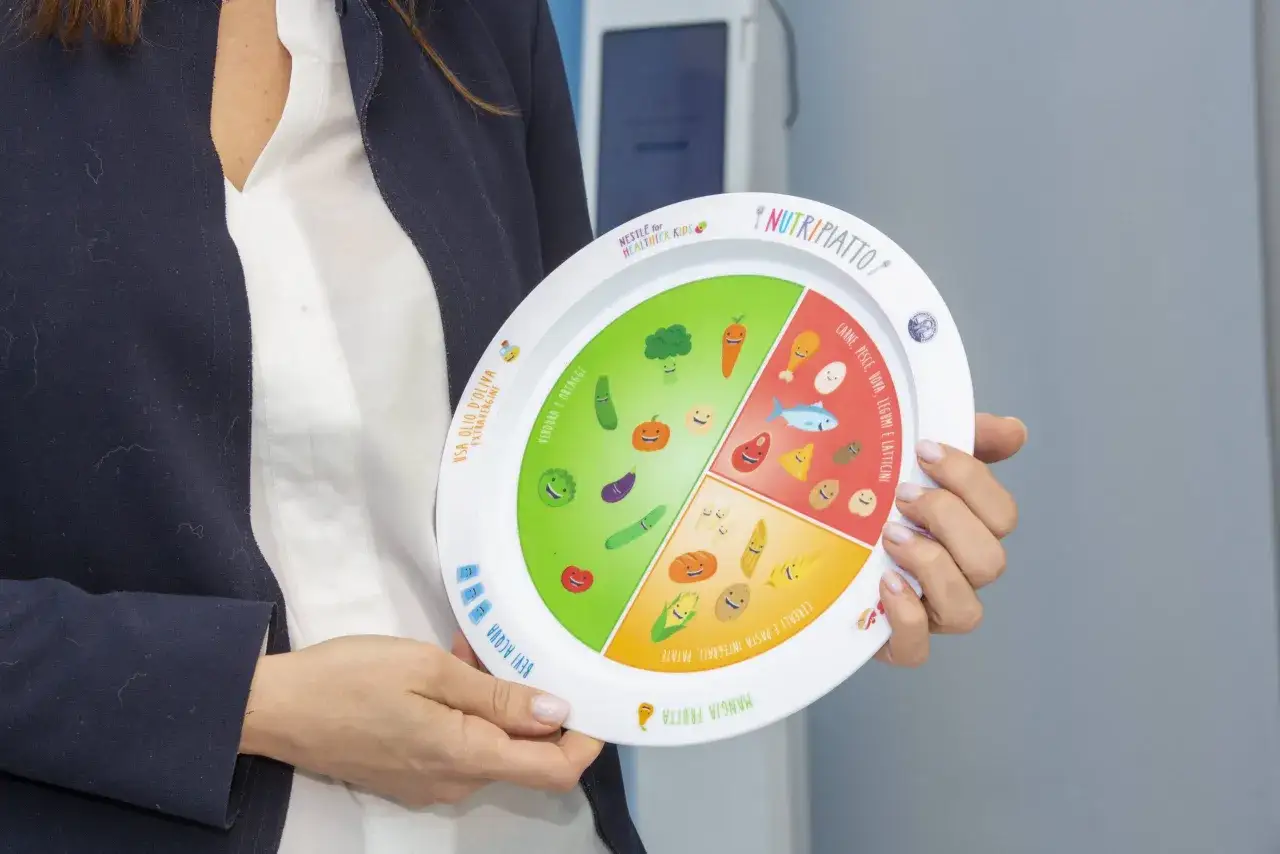 Un piatto diviso per guidare un esempio dieta in gravidanza per non ingrassare, con verdure, frutta, cereali e proteine.