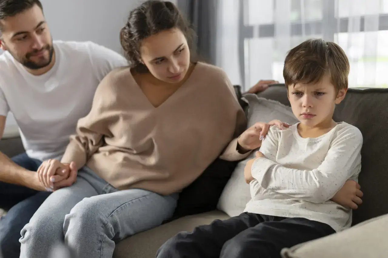 Genitori preoccupati cercano di capire i disturbi comportamentali di un bambino di 7 anni, con lui visibilmente turbato.