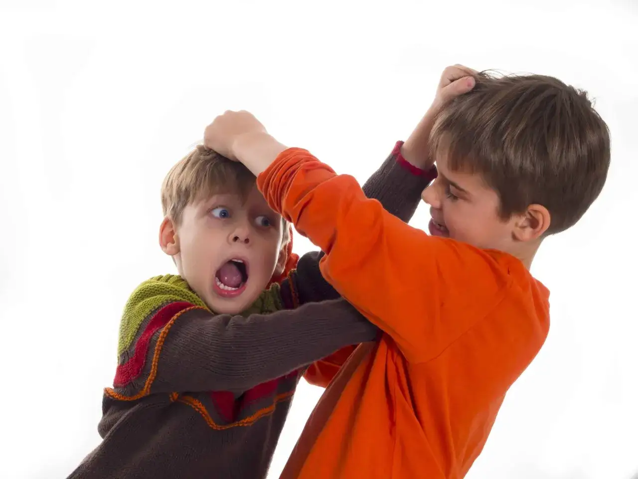 Due bambini litigano, uno afferra i capelli dell'altro. Un esempio di litigi tra fratelli psicologia, un'interazione comune ma complessa.