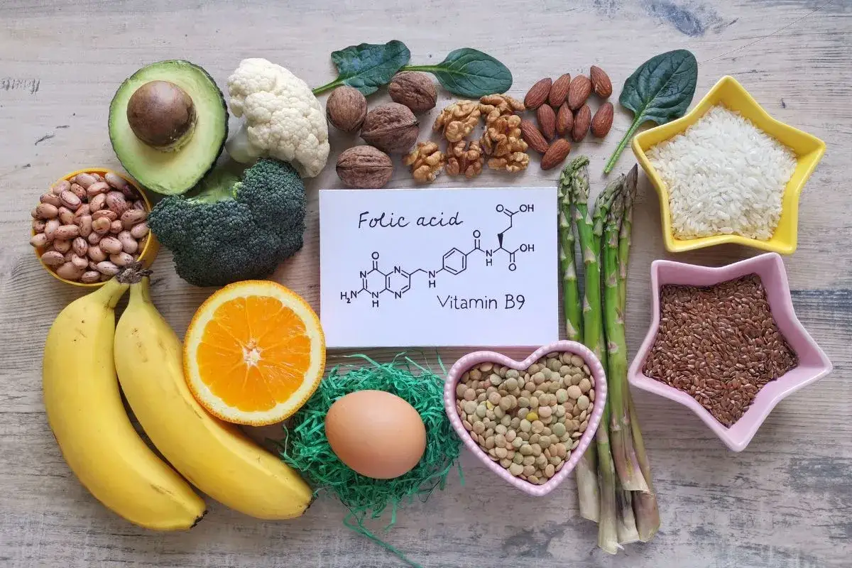 Alimenti ricchi di acido folico, essenziale per la gravidanza: frutta, verdura, legumi, noci, uova e cereali.