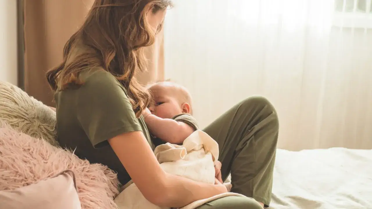 Mamma allatta il suo bambino, un momento tenero che anticipa la lallazione quando inizia.