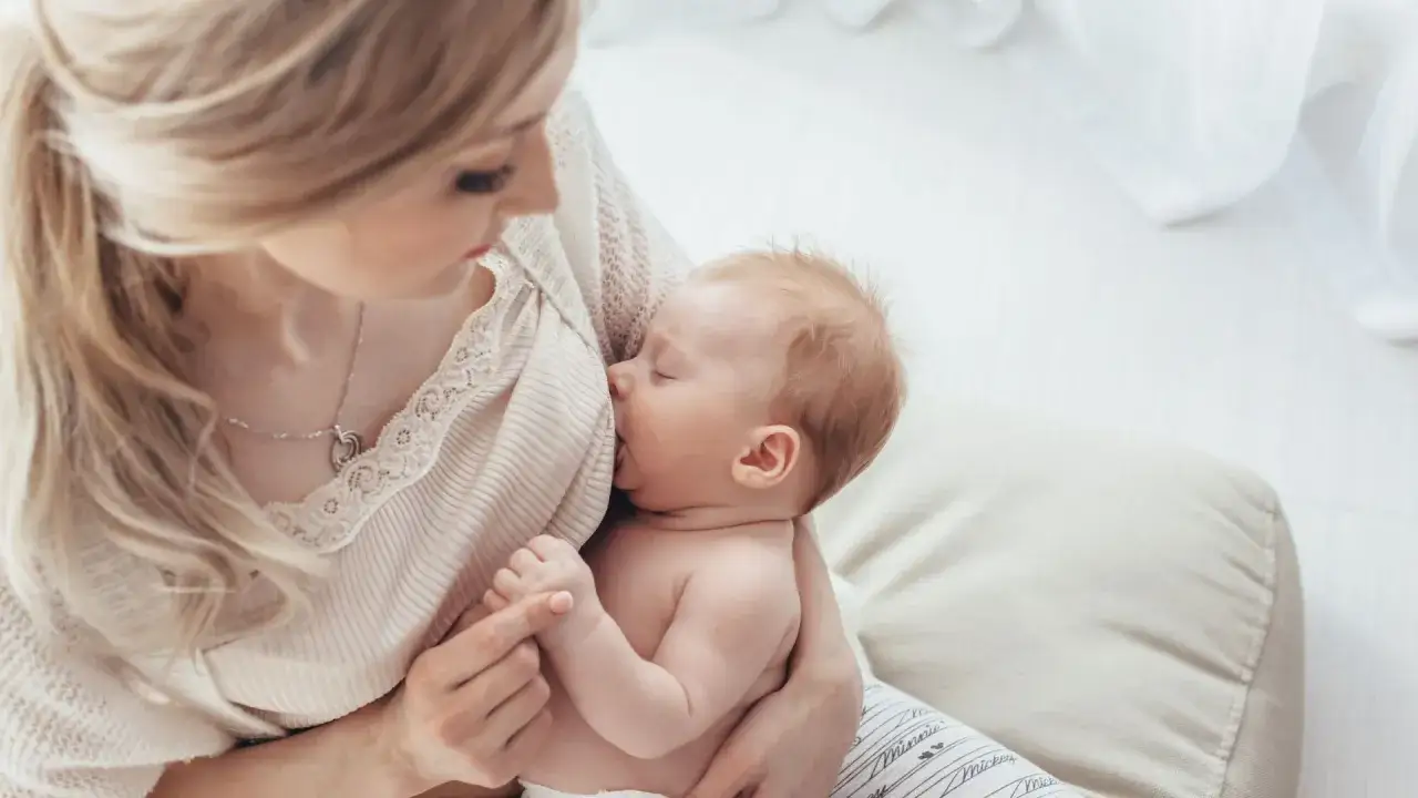 Mamma bionda allatta il suo neonato. In caso di febbre o dolore, il brufen in allattamento è un'opzione da valutare con il medico.