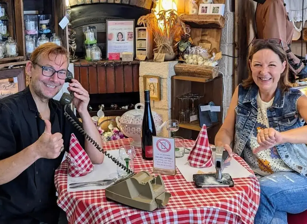 Coppia che si gode del tempo di qualità, lui al telefono, lei con un martello su uno smartphone.