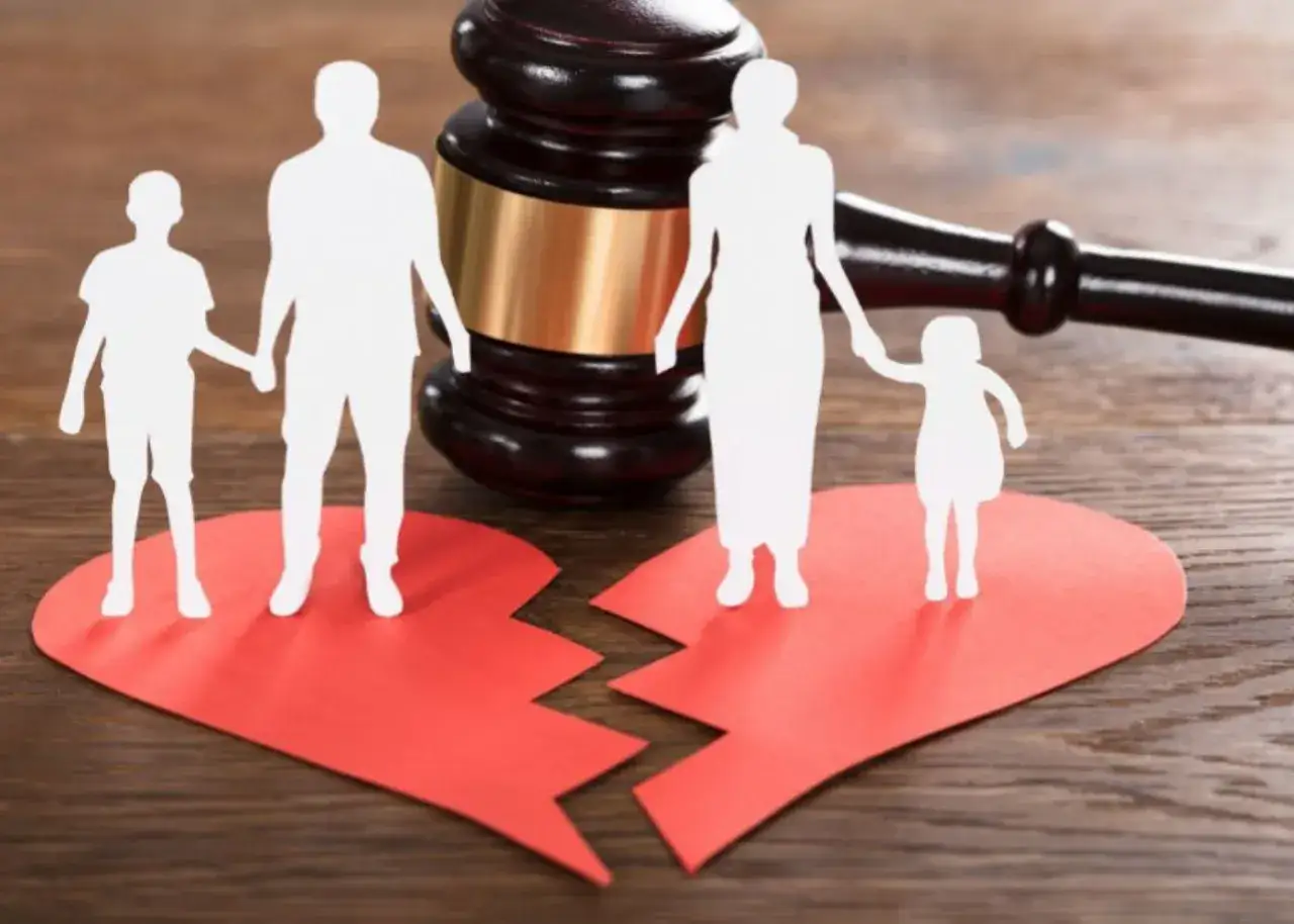 Un martelletto da giudice e sagome di famiglia su un cuore spezzato. Un'immagine che simboleggia come affrontare una separazione e le sue conseguenze legali.